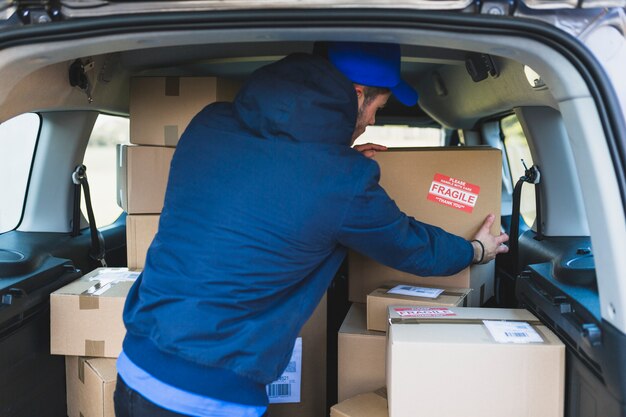 Deliveryman in car with carton boxes