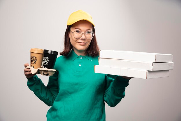 Deliverywoman holding cardboard of coffee cups on a white. High quality photo