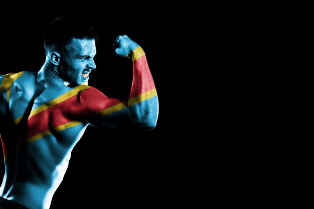 Free photo democratic republic of congo flag on handsome young muscular man black background