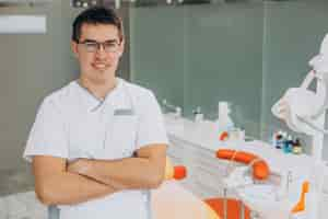 Free photo dental doctor standing at clinic