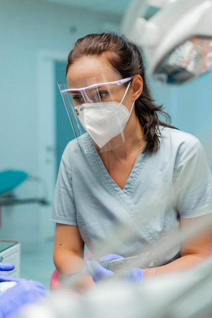 Assistente dentista nel processo di lavoro ritratto del primo piano.