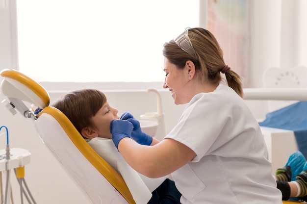 Foto gratuita dentista che pulisce i denti del bambino