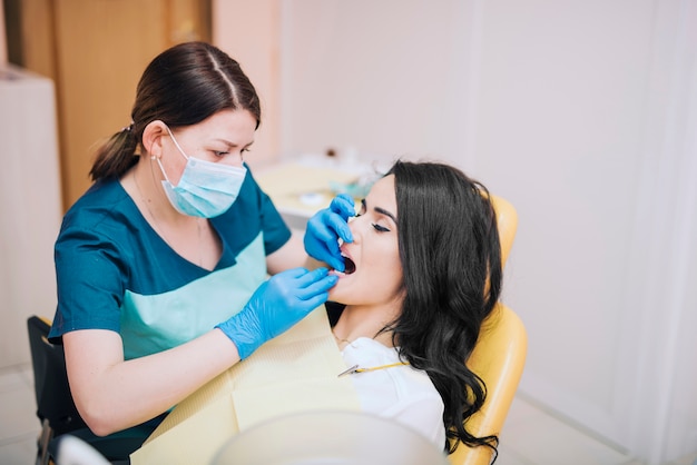 Dentista che cura i denti del paziente