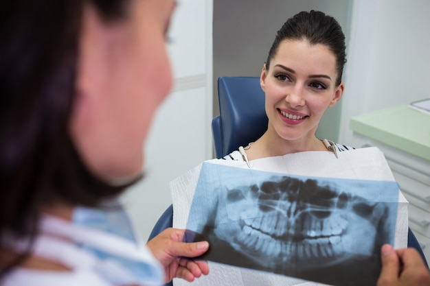 Foto gratuita dentista che discute con il paziente sul rapporto dei raggi x