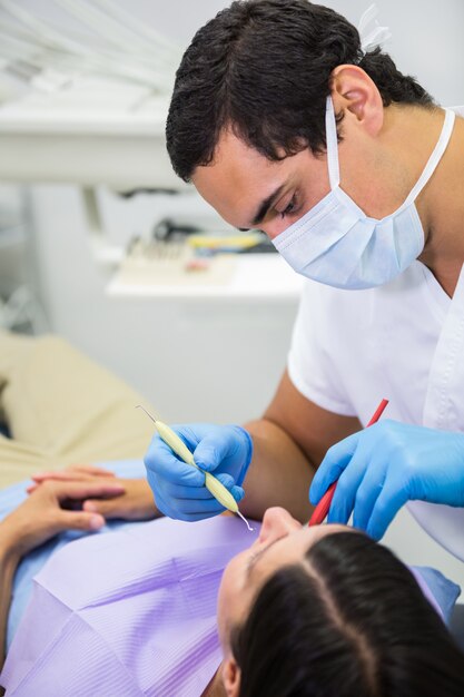 歯科医が女性患者の口腔検査を行う