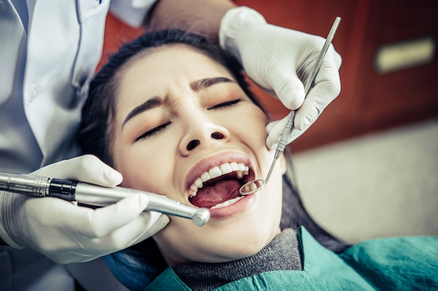 치과 의사는 환자의 치아를 검사합니다.
