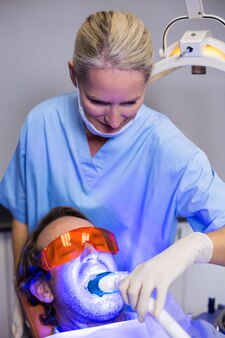 치과 의사 치과 도구로 남성 환자를 검사