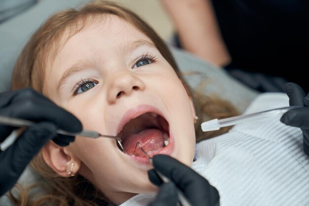 Dentist examining condition of teeth of little patient