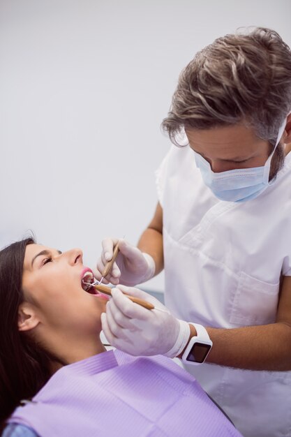 Dentist examining female patient teeth