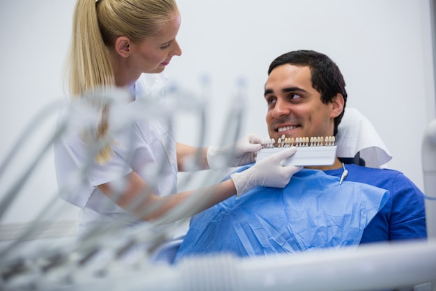 無料写真 歯科医が歯の色合いを持つ女性患者を調べる