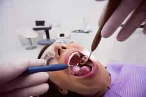 Free photo dentist examining a female patient with tools