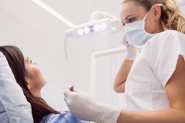 Dentist examining female patient