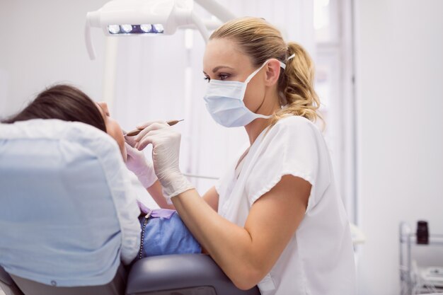 Dentist examining female patient