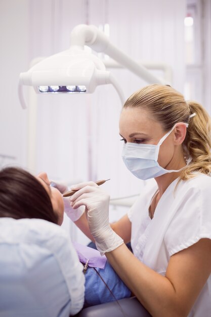 Dentist examining female patient