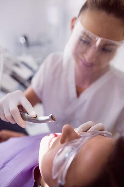 Dentist examining female patient