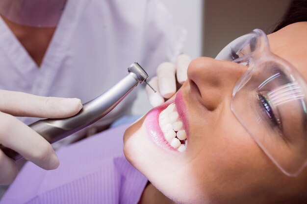 Dentist examining female patient