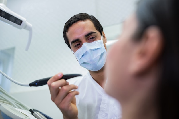 Dentist examining female patient