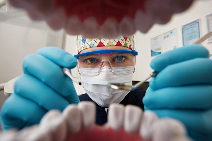 Free Photo dentist examining mouth of patient