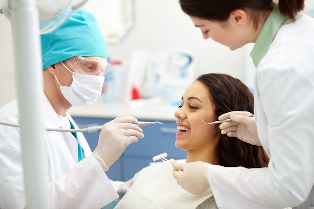 Foto gratuita dentista esaminando denti di un paziente