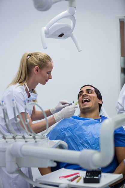 Dentist examining a patient with tools