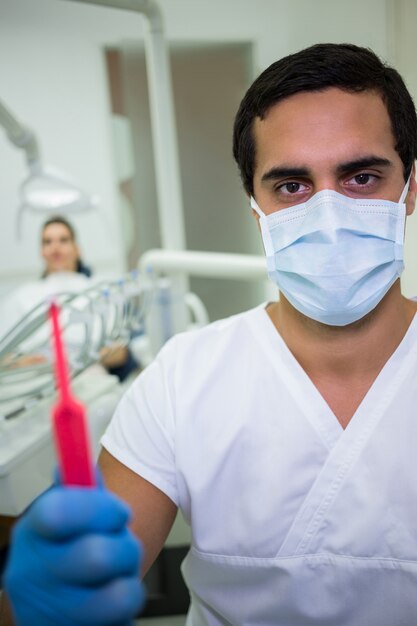 Dentist holding dental tools in dental clinic