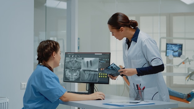 Dentist holding dentition x ray scan comparing to radiography