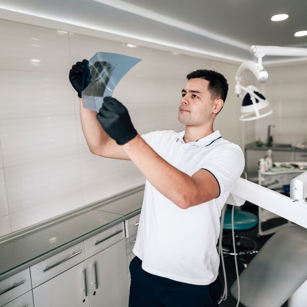 Dentist holding radiography in office