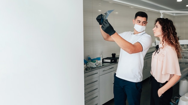 Dentist holding radiography with patient and copy space