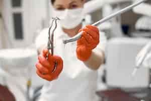 Free photo dentist is preparing for the reception.doctor with his equipment.woman looking at the camera