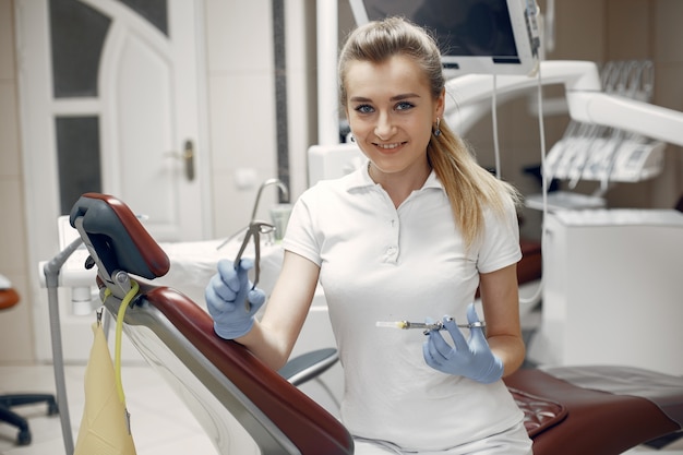 The dentist is preparing for the reception.Doctor with his tool.Woman looking at the camera