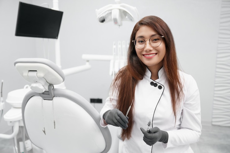 Free Photo dentist keeping dental tools and smiling in clinic