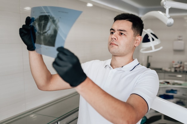 Бесплатное фото Стоматолог, глядя на рентгенографии в офисе