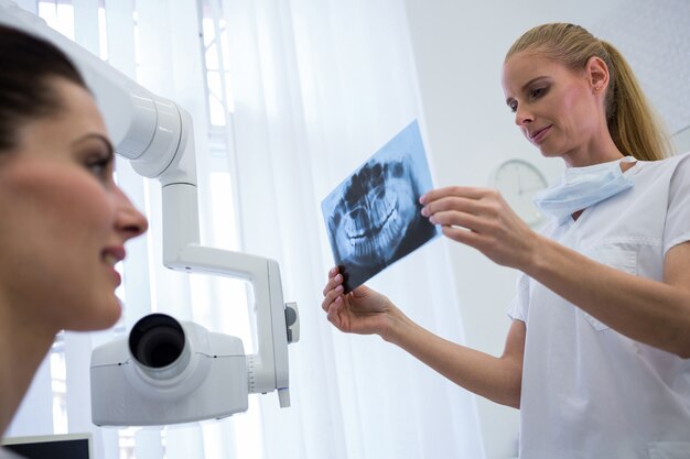 Dentist looking at x-ray in front of patient
