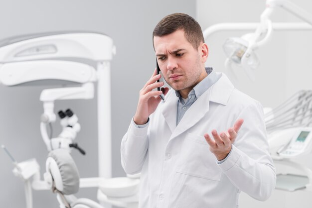 Стоматолог делает телефонный звонок