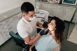 Free photo dentist performing a check-up on patient in office