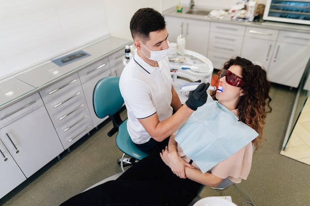 Foto gratuita dentista che esegue sbiancamento sul paziente