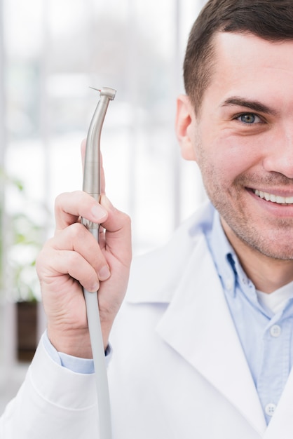 Стоматолог, представляя инструмент
