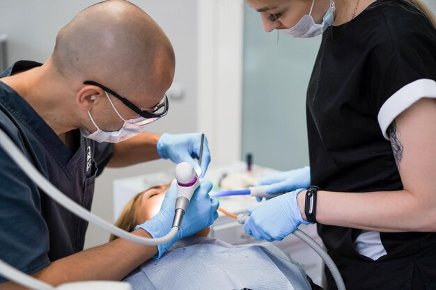 Стоматолог в процессе. Стоматологические услуги, стоматологический кабинет, лечение зубов.