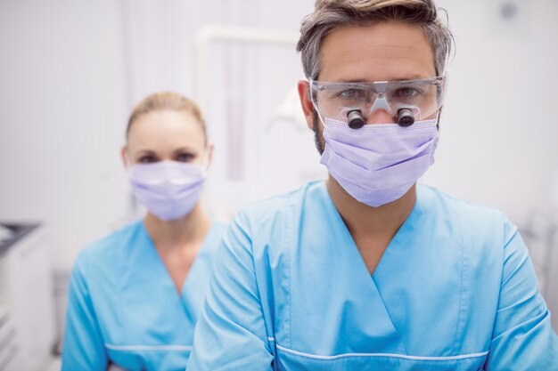Стоматолог, стоя в стоматологической клинике