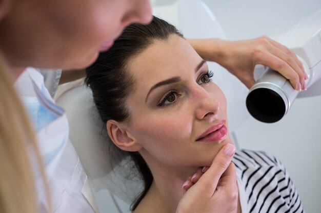 Dentist taking a female patients tooth x-ray