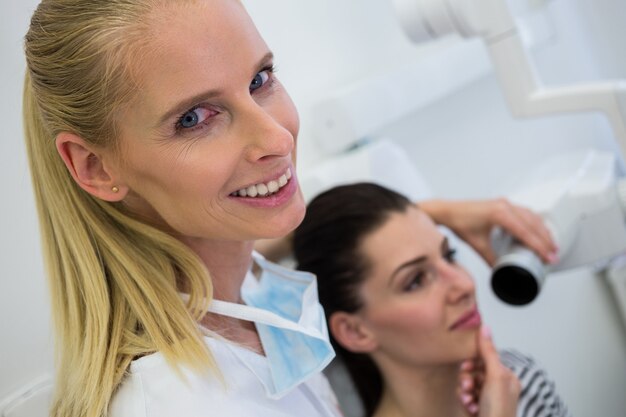 Dentist taking a female patients tooth x-ray