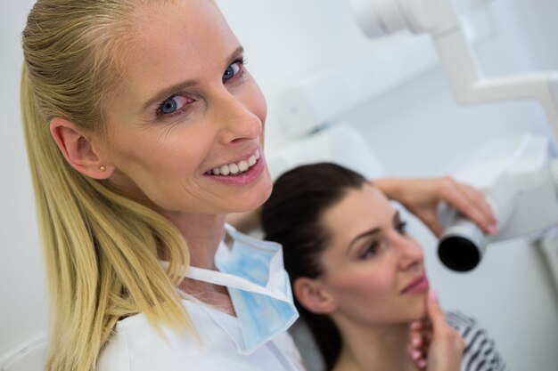 歯科医は女性患者の歯のx線を撮影