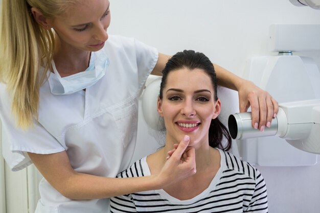 Dentist taking a female patients tooth x-ray