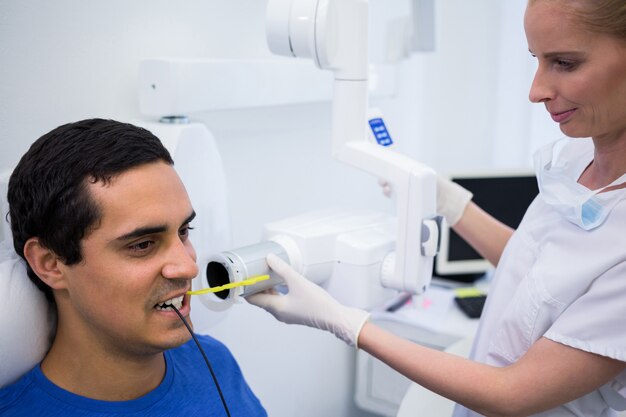 Dentist taking a male patients tooth x-ray