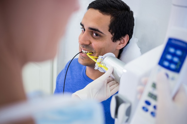 Стоматолог, принимая рентген пациентов зубов