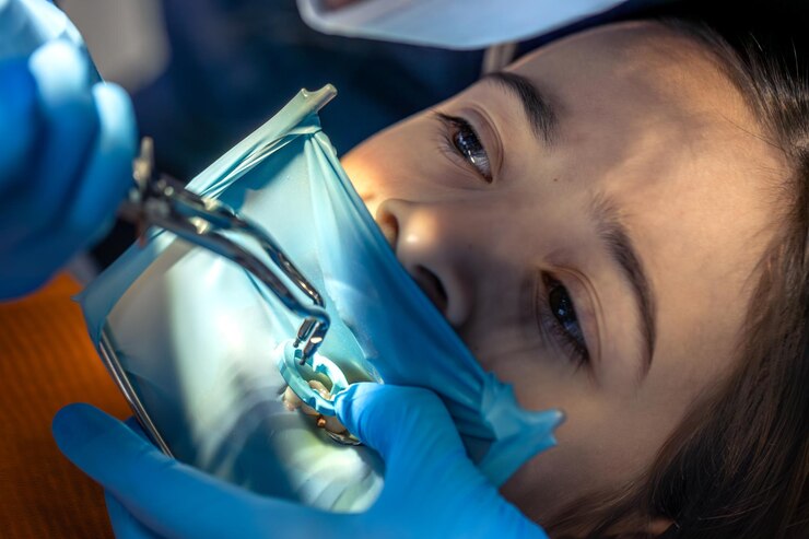 Free Photo the dentist treats the childs tooth using a rubber dam closeup of tooth treatment