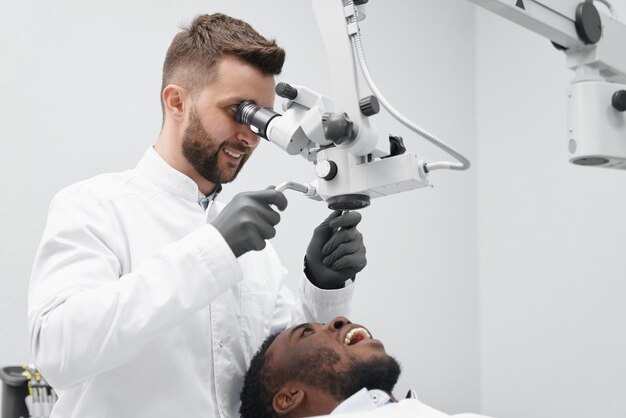 Dentist working while patient lying on chair with open mouth