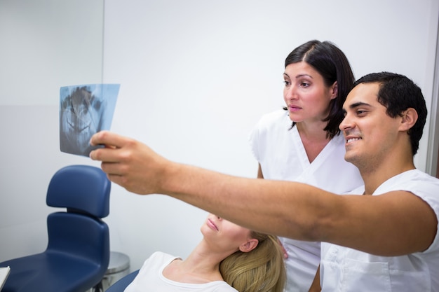 Dentists discussing x-ray in front of patient