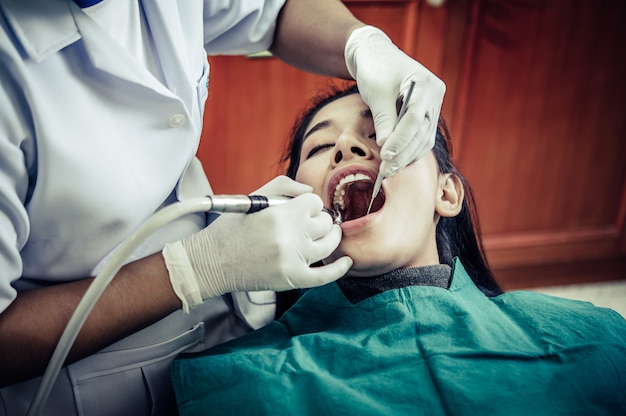 歯科医は患者の歯を治療します。