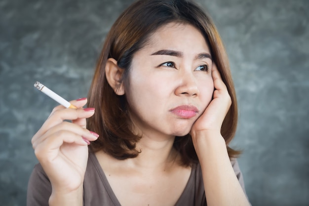 Premium Photo | Depressed asian woman smoking cigarette with unhappy face